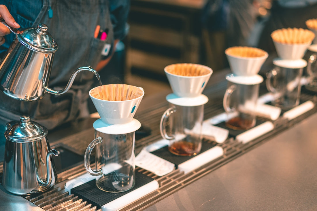 a line of coffee cups sitting on top of a counter