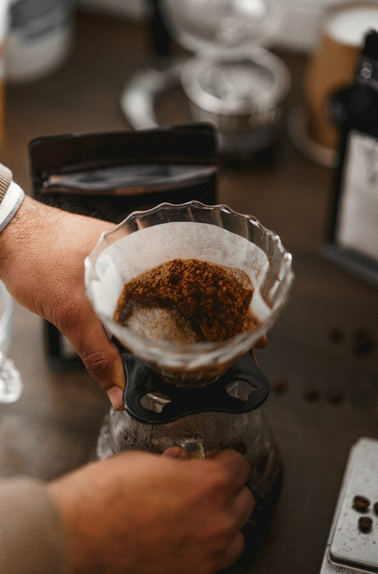 a person pours coffee into a cup