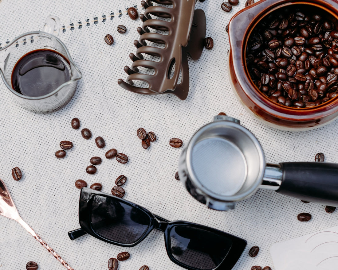 Coffee beans and espresso machine parts on a surface.