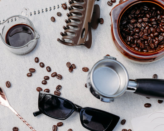 Coffee beans and espresso machine parts on a surface.
